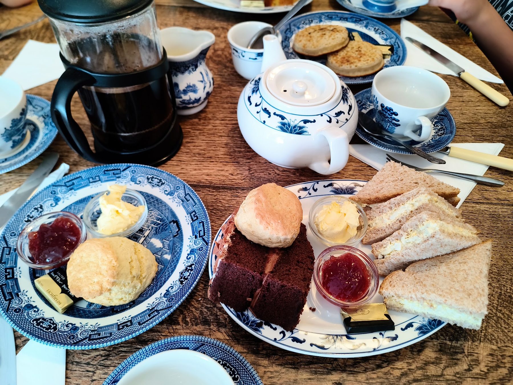 Afternoon tea on blue and white china: scones, cake, sandwiches and a teapot