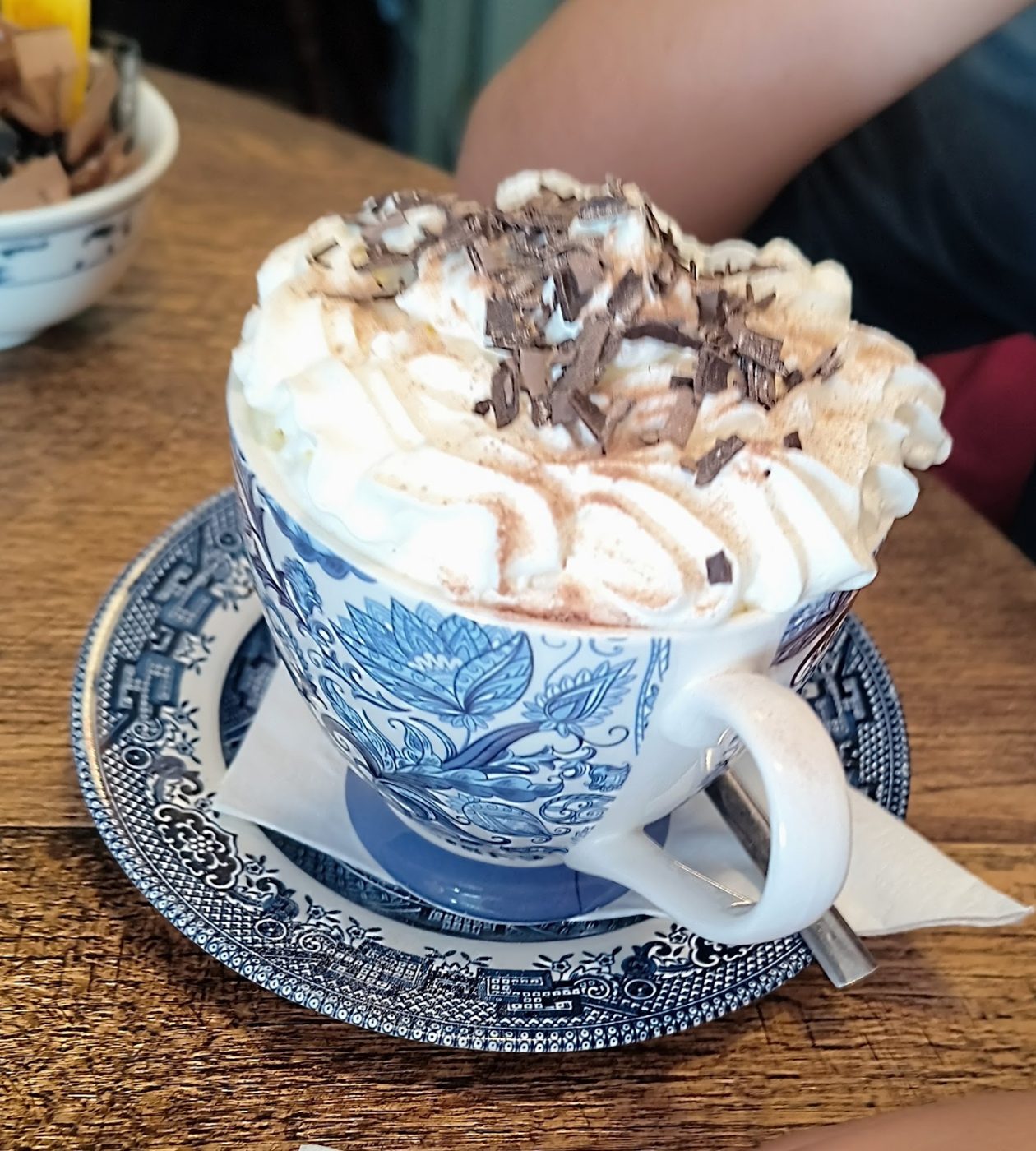 A hot chocolate topped with cream and chocolate shavings