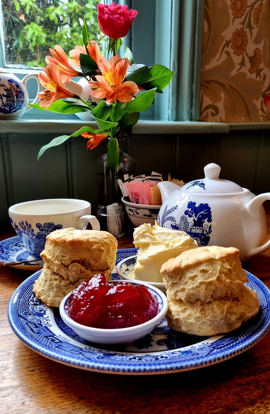 Scones with jam, a teapot and flowers