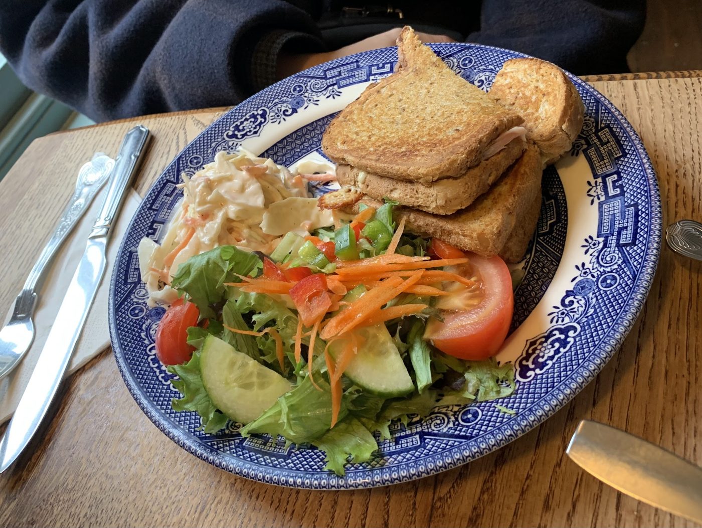 A toasted sandwich with salad